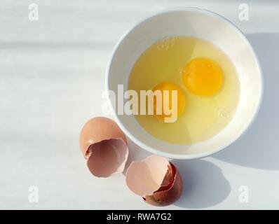 Deux œufs fouettés, et coquille d'oeuf avec le blanc d'oeuf dans un petit bol, Allemagne Banque D'Images