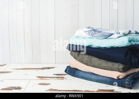 Une pile de vêtements de femmes sur des tableaux blancs avec une copie de l'espace Banque D'Images