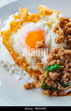 Garni de riz sauté de porc et de basilic frit servi avec des oeufs, de la nourriture thaïe. Banque D'Images