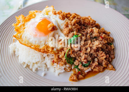 Garni de riz sauté de porc et de basilic frit servi avec des oeufs, de la nourriture thaïe. Banque D'Images