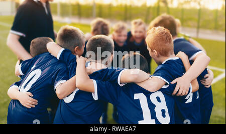 Les garçons Sport Team Huddle. Les enfants de l'équipe de football se sont réunis avant le tournoi finale. Jeunes joueurs de football et entraîneur de l'entassement. Les compétitions sportives Banque D'Images