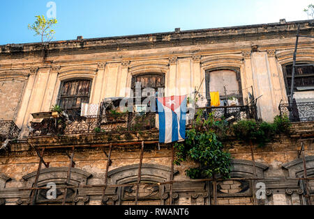 Un drapeau cubain est suspendu au balcon d'un immeuble délabré dans le centre de La Havane, capitale de Cuba Banque D'Images