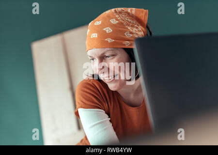 Happy smiling female carpenter lors de chat en ligne avec le client sur un ordinateur portable dans l'atelier de menuiserie Banque D'Images