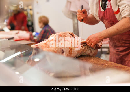 Butcher vend la viande de boeuf haché dans un marché Banque D'Images