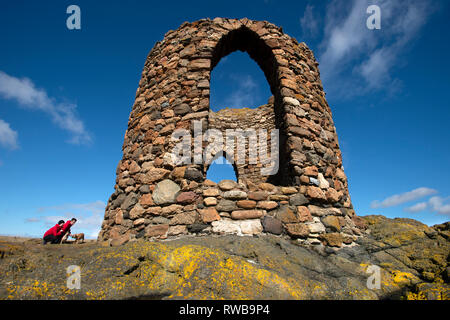 Deux touristes et leur chien crouch à côté de Lady's Tower à Elie Fife sur la côte est de l'Ecosse UK Banque D'Images