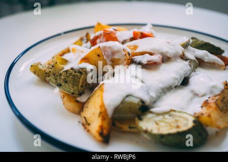 Cuisine turque Kizartma, nourriture, légumes frits avec du yogourt.aubergine frite, courges, pommes de terre, les tomates, les épices et le yaourt servi sur une assiette. Banque D'Images