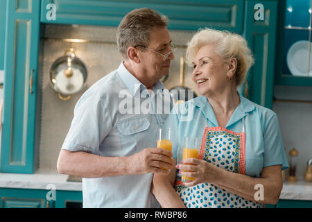 Vieux couple heureux boire du jus Banque D'Images