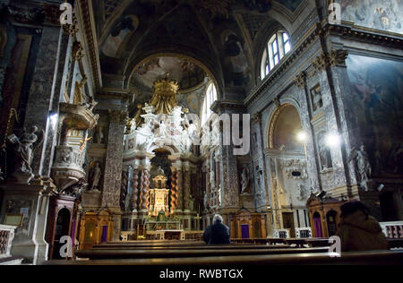 Un seul homme dans une proie Venician ornate church. Banque D'Images