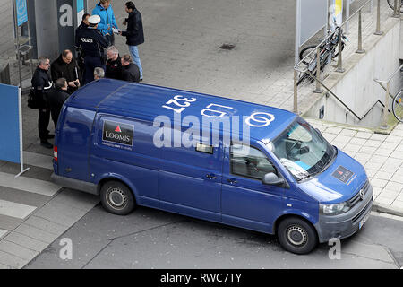 06 mars 2019, en Rhénanie du Nord-Westphalie, Köln : policiers et la sécurité des employés d'une entreprise sont debout à une voiture blindée. Au moins un coup de feu a été tiré le mercredi au cours d'un vol d'un transporteur d'argent à l'aéroport Cologne/Bonn. Photo : Oliver Berg/dpa Banque D'Images