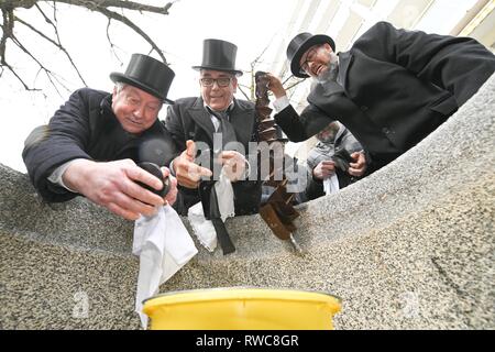 Friedrichshafen, Allemagne. 08Th Mar, 2019. Deuil imbéciles en queue avec manteaux et chapeaux haut-de-cry après le traditionnel sac de blanchisserie le passé carnaval. Après la douane, les imbéciles laver leur portefeuille sur le Mercredi des Cendres dans la fontaine de la ville de Friedrichshafen Hofen. Crédit : Felix Kästle/dpa/Alamy Live News Banque D'Images