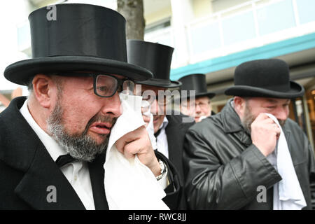 Friedrichshafen, Allemagne. 08Th Mar, 2019. Deuil imbéciles en queue avec manteaux et chapeaux haut-de-cry après le traditionnel sac de blanchisserie le passé carnaval. Après la douane, les imbéciles laver leur portefeuille sur le Mercredi des Cendres dans la fontaine de la ville de Friedrichshafen Hofen. Crédit : Felix Kästle/dpa/Alamy Live News Banque D'Images