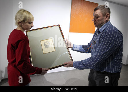 6 mars 2019 - Kiev, Ukraine - Les employés portent la peinture de l'auto-portrait par l'artiste russe Kazimir Malevich , lors de l'ouverture de l'exposition ''l'avant-garde. À la recherche de la quatrième dimension'' dans le centre d'art moderne ''M17'' à Kiev, Ukraine, le 06 mars 2019. Selon les représentants du M17, pour la première fois en Ukraine a présenté un autoportrait inédites par l'artiste russe Kazimir Malevich, laquelle il peint 11 mois avant sa mort. «Maintenant je suis comme Marx dans une tombe. Quand je sors, le cri des enfants, Karl Marx'' signé l'auteur sur un auto-portrait, peint Banque D'Images