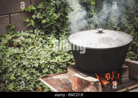 Chaudron noir fermé l'ébullition sur un feu de joie. La préparation de soupe Chorba de plein air Banque D'Images