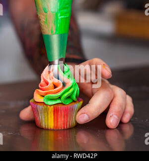 Cupcakes colorés avec rainbow crème pour Carnival Banque D'Images