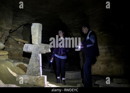 Guide explique le rôle de l'église souterraine dans les catacombes trouvée dessous Odessa, Ukraine Banque D'Images