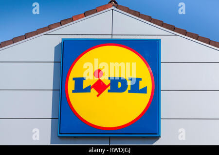 Le signe et le logo Lidl contre un ciel bleu sur l'avant du magasin Lidl à Farnham, Surrey. Banque D'Images