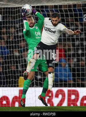 Derby County's Bradley Johnson et gardien de Wigan Athletic Jamie Jones bataille pour une balle haute au cours de la Sky Bet Championship match à Pride Park, Derby. Banque D'Images