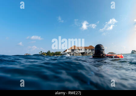 Plongée sous marine sur la surface de la mer près de tropical resort bungalow sur pilotis Banque D'Images