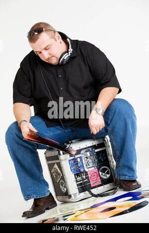 Discjockey avec les disques vinyles et les écouteurs. Banque D'Images