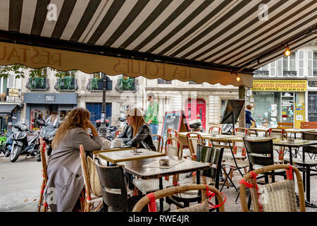 Deux femmes assises à l'extérieur à une table dans un restaurant parisien de St Georges dans le 9ème Arrondissementt de Paris, France Banque D'Images