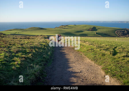 Les Amis à marcher le long de la pointe de la queue, un spectaculaire promenade côtière de Bolberry jusqu'à Hope Cove sur la côte sud du Devon, UK Banque D'Images