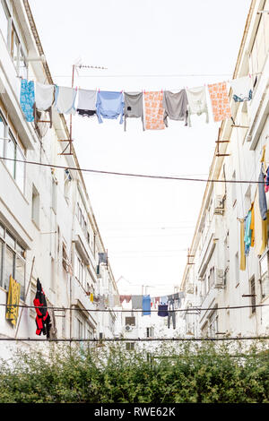 Vêtements lavés accroché entre bâtiments residencial à Ayamonte, Andalousie, Espagne Banque D'Images