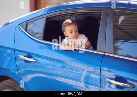 Bébé fille look sur route à partir de la fenêtre de voiture Banque D'Images