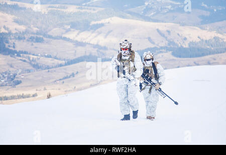 Les militaires de l'armée en hiver camo quelque part dans les montagnes. Banque D'Images