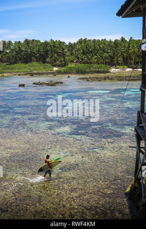 Surfer Walking on Beach with Surfboard - Cloud 9 Boardwalk - Siargao, Philippines Banque D'Images