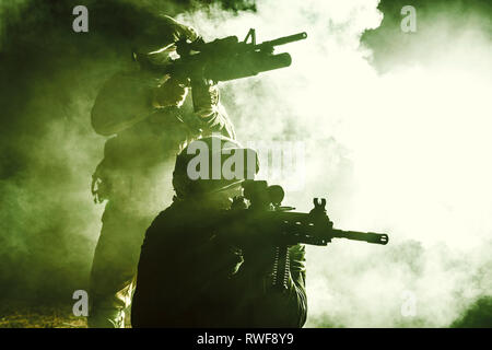 Silhouettes noires de paire de soldats dans la fumée au cours d'une bataille. Banque D'Images