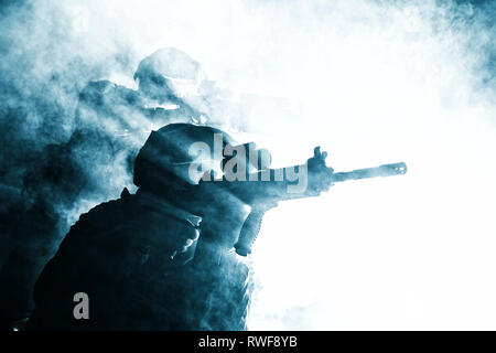 Silhouettes noires de paire de soldats dans la fumée au cours d'une bataille. Banque D'Images