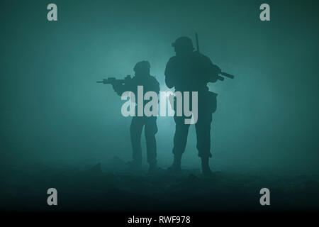 Silhouettes noires de paire de soldats dans le brouillard de fumée au cours d'une bataille. Banque D'Images