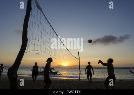 Jeu et joueurs de volley-ball sur plage de General Luna au coucher du soleil - Siargao, Philippines Banque D'Images