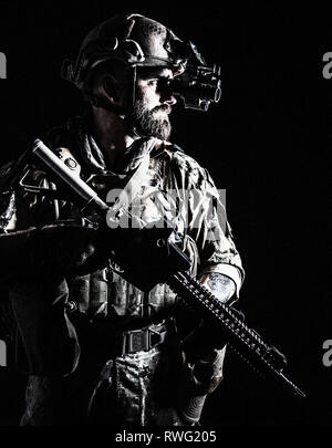 Studio photo de rétroéclairage contour soldat en uniforme des forces spéciales avec arme. Banque D'Images