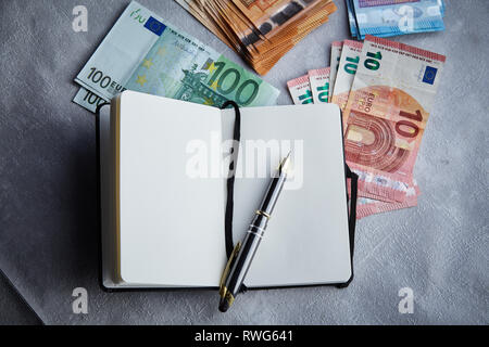 Ordinateur portable ouvert avec beaucoup d'euros sur la table à proximité -jusqu'Vue supérieure Business Concept Banque D'Images