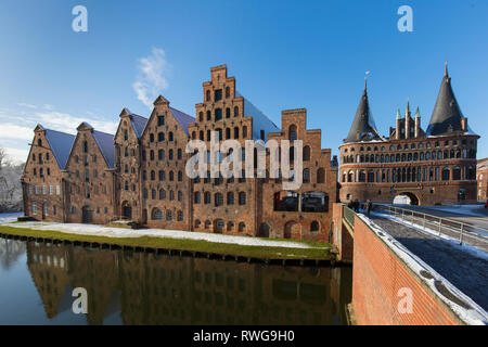 Des entrepôts de sel historique (Salzspeicher) et l'Holsten Gate sur la rivière Trave à Luebeck en hiver. Schleswig-Holstein, Allemagne Banque D'Images