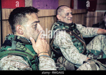 Les Marines américains à parler et se reposer tout en étant assis sur le plancher à leur poste de combat. Banque D'Images