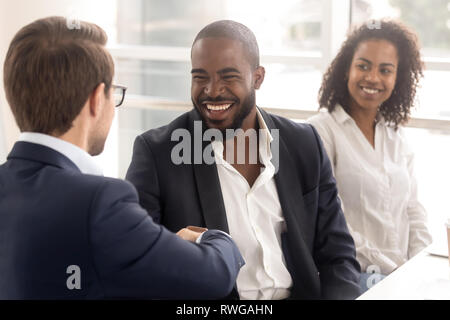 Multi-ethnic colleagues shaking hands chaque message d'information au cours d'autres Banque D'Images