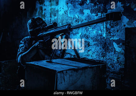 Un tir de sniper calibre 50 fusil de sniper dans la nuit lors d'une mission de combat en zone urbaine. Banque D'Images