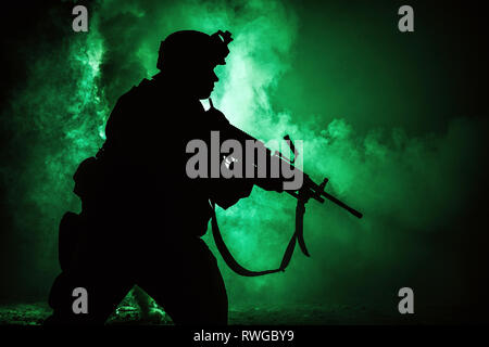 Silhouette de soldat d'infanterie moderne debout avec fusil d'assaut sur fond de couleur. Banque D'Images