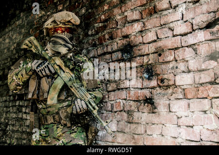 Opérateur de forces d'opérations spéciales russes avec fusil d'assaut Kalachnikov en bâtiment en ruine. Banque D'Images