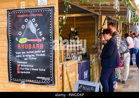 Les gens occupés à Wakefield Food, Drink & Rhubarb Festival 2019 marché en échange de la vente de bouteilles de gin - West Yorkshire, Angleterre, Royaume-Uni Banque D'Images