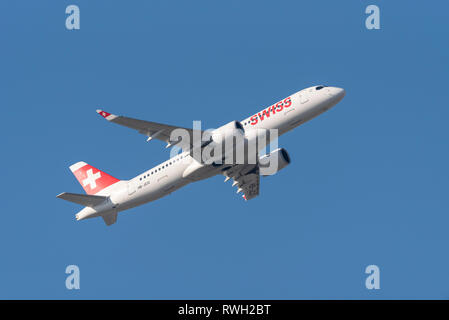 Avion à réaction suisse Airbus A220 HB-JCO décollant de l'aéroport de Londres Heathrow, Royaume-Uni, dans un ciel bleu. Swiss International Air Lines Banque D'Images