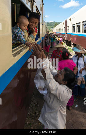 KALAW, MYANMAR - 23 novembre, 2018 : Vertical Photo de femme birmane traditionnelle demandant de porter le bébé sur le chemin de fer à Kalaw, Myanmar Banque D'Images