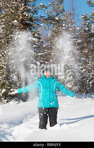 Nerungry Neryungry, District, Yakoutie, Russie. Le 5 février 2017 Femme lance de la neige dans la forêt d'hiver Banque D'Images