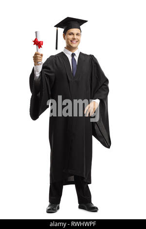 Portrait of a young man in a black graduation gown et titulaire d'un diplôme cap isolé sur fond blanc Banque D'Images
