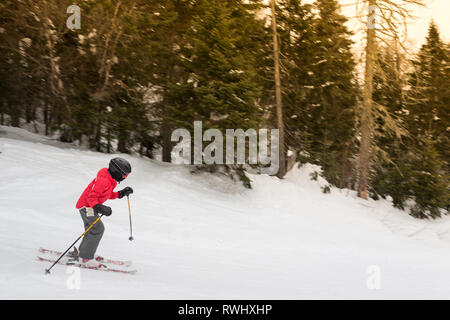 Enfant portant des skis d'hiver d'une montagne Banque D'Images