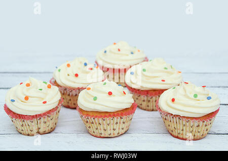 Biscuit cupcakes avec de la crème dans des formulaires papier. On a white background. Banque D'Images