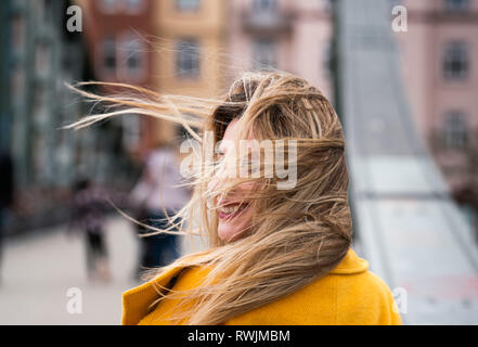 07 mars 2019, Hessen, Frankfurt/Main : un touriste de Tirana en Albanie est debout sur le pont de fer dans le vent fort, alors qu'elle est photographiée par un autre voyageur. Photo : Frank Rumpenhorst/dpa Banque D'Images