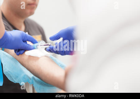 Praticien de laboratoire de l'extraction du sang d'un patient Banque D'Images